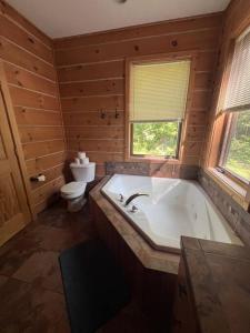 een grote badkamer met een bad en een toilet bij Welcome to Bear's Den Lodge in Round Lake Seaplane Base +21 foto's