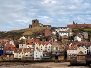 a town with a castle on top of a hill at Number 3 Pier Road Suites in Whitby