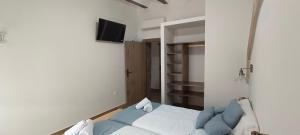 a bedroom with a bed and a tv on a wall at Apartamentos Casa de los Galeote in Baeza