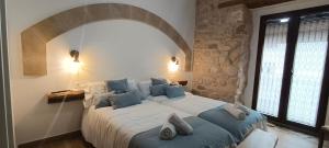 a bedroom with a large white bed with blue pillows at Apartamentos Casa de los Galeote in Baeza +36 photos