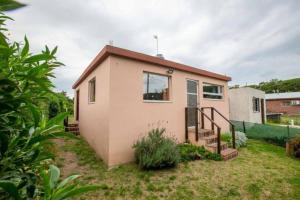 a small house with a staircase in a yard at Casa, Bosque y Mar in Miramar