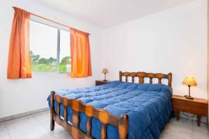 a bedroom with a bed and a large window at Casa, Bosque y Mar in Miramar