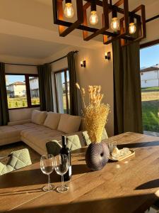 a living room with a couch and a table with wine glasses at Villa Vista in Dolna Banya