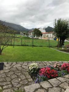 a stone walkway with flowers in a park at Hotel Rural Villa Elena in Panes