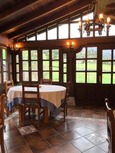 a dining room with a table and some windows at Hotel Rural Villa Elena in Panes