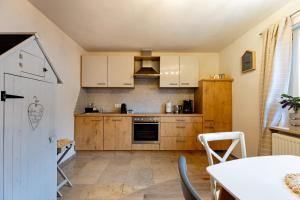 a kitchen with wooden cabinets and a table with chairs at Laura‘s Heimat in Bad Bergzabern