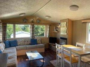 a living room with a couch and a table at Rockley Park - Coral in Poole