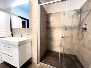 a bathroom with a sink and a shower at Apartmán Manhattan s terasou v centre mesta in Trenčín +9 photos