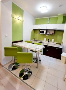 ブダペストにあるEötvös Apartmanの緑の壁のキッチン(テーブル、椅子付)