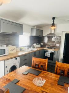 a kitchen with a wooden table and a counter top at Rj s house in Merthyr Tydfil