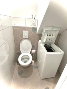 a small bathroom with a toilet and a washing machine at Relax & Cosy Saint Just Saint Rambert in Saint-Rambert-sur-Loire +6 photos