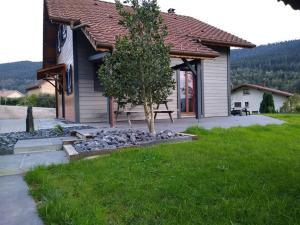 a house with a tree in front of a yard at Superbe chalet Hautes Vosges in Cornimont