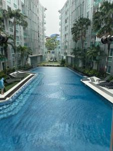 a large swimming pool in the middle of two buildings at City Center Residence Pattaya in Pattaya Central
