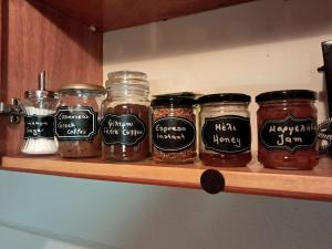 a shelf with many jars of jam on it at El-Mi's little house in Theologos in Theológos +9 photos