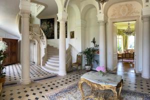 a large room with a staircase and a table at Château du Maurier in La Fontaine-Saint-Martin