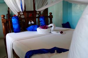 ein Schlafzimmer mit einem Bett mit Schwanenhand in der Unterkunft Princess Salme Inn in Zanzibar City