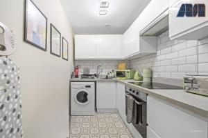 a white kitchen with a washing machine in it at Elegant 2Bed Sleeps 4 With Parking in Paisley +23 photos