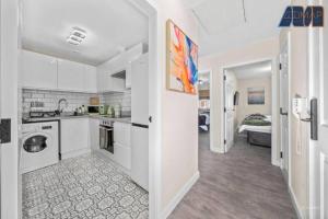 a large white kitchen with a sink and a stove at Elegant 2Bed Sleeps 4 With Parking in Paisley