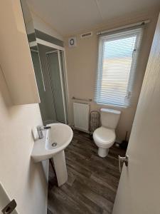 ein Badezimmer mit Toilette und Waschbecken in der Unterkunft Palm Grove 121 - Golden Palm Resort - Pet friendly, WiFi, close to beach and clubhouse - Meadow Lakes Caravan & Lodge Hire in Chapel Saint Leonards