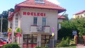 un edificio con un cartel de noel en el costado. en Noclegi Helvet, en Ustrzyki Dolne