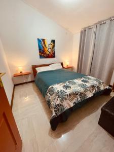 a bedroom with a bed and two lamps and a window at La Kaz Sainte Anne in Saint-Benoît