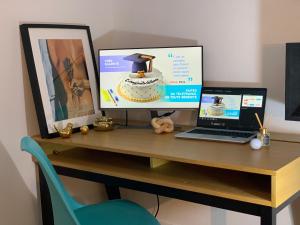 a desk with a computer and a laptop on it at Appartement Cosy et Kaliente in La Courneuve