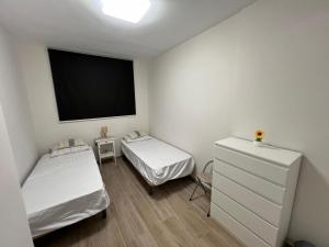 a room with two beds and a flat screen tv at Cura Sea View Apartment in Playa del Cura +26 photos