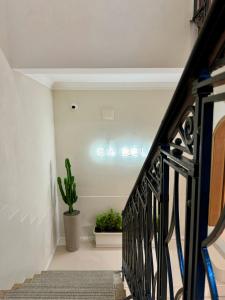 a staircase with a black railing and a plant at Cà Bèla - Mercadante in Milan