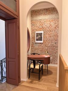 a dining room with a table and a brick wall at Cà Bèla - Mercadante in Milan