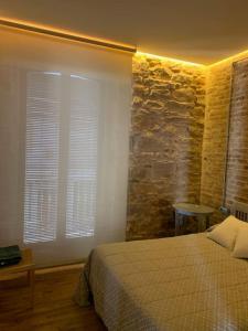 a bedroom with a bed and a stone wall at Casa del Párroco in La Carolina +13 photos