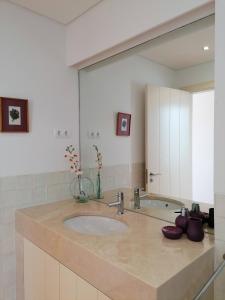 a bathroom with a sink and a large mirror at Villa Martin in Óbidos