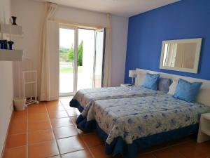 a blue bedroom with a bed with a blue wall at Villa Martin in Óbidos