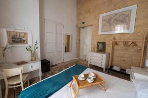 a bedroom with a bed and a desk and a table at Blue House 9 Rooms & Breakfast in Birgu