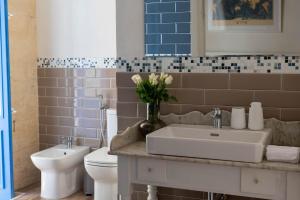 a bathroom with a sink and a toilet at Blue House 9 Rooms & Breakfast in Birgu