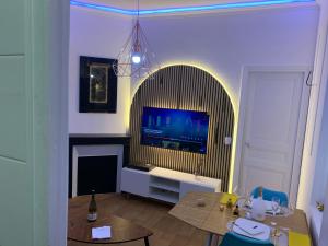 a living room with a television and a table with a table at Appartement Cosy et Kaliente in La Courneuve