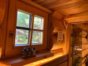 a window in a wooden room with bottles on a shelf at Russet & Rowanberry - Rowanberry Retreat in Kriilevälja +39 photos