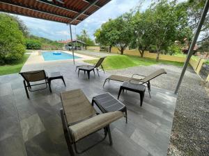 a patio with chairs and tables and a pool at Casa Fofo in San Carlos