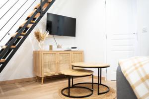 a living room with two stools and a tv at Maison Cosy Centre Gare Amiens in Amiens