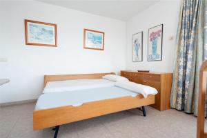 sypialnia z łóżkiem i komodą w obiekcie Apartamentos Xaloc HRC w Cala Millor