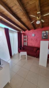 a living room with a red couch and a table at La Dea Busa in Canosa di Puglia