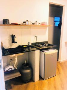 a small kitchen with a stove and a sink at Flats do Cordeiro in Cabo Frio