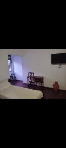 a room with two beds and two chairs and a television at Suítes no centro in Belém
