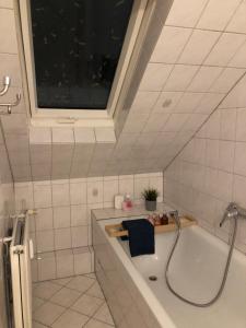 ジーゲンにあるSiegen Zentral Ferienwohnung 1 bis zum12 Schlafplätzeのバスタブと窓のあるバスルーム +40枚の写真