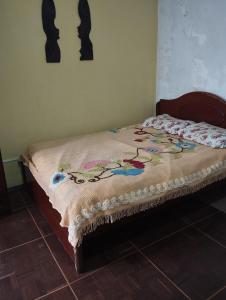 a bed with a blanket on it in a bedroom at Suítes no centro in Belém
