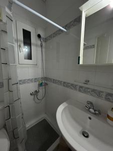 a white bathroom with a sink and a shower at Ria's Home in Athens