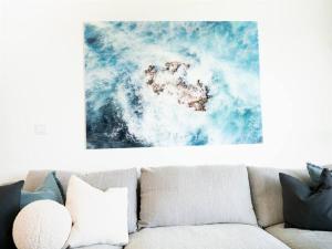 a living room with a couch with a picture on the wall at Premier Palaca - ground floor only, walk to reserve & town in Santo Isidoro