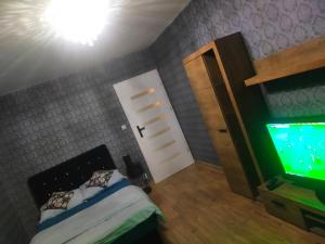 a small bedroom with a bed and a television at Apartament Chopina 17 in Włocławek