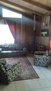 a living room with couches and a rug at Cabañas Marisol in Villarrica