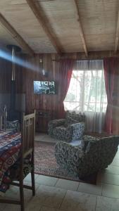 a living room with two couches and a television at Cabañas Marisol in Villarrica