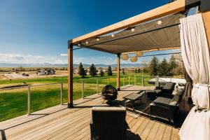 a wooden deck with a grill and chairs on it at Contemporary Wyoming Luxury in Sheridan